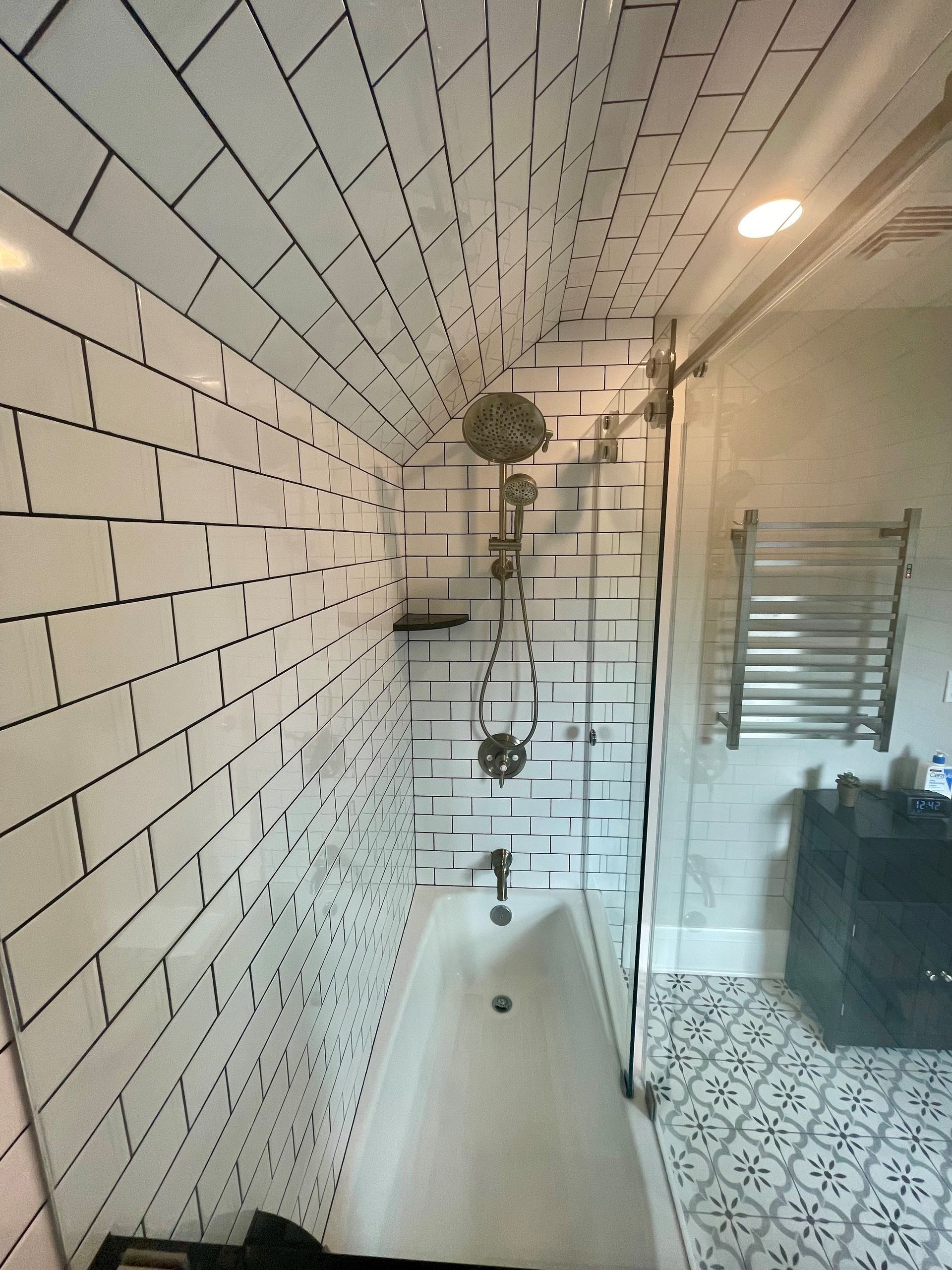 A bathroom with white subway tiles and a bathtub.
