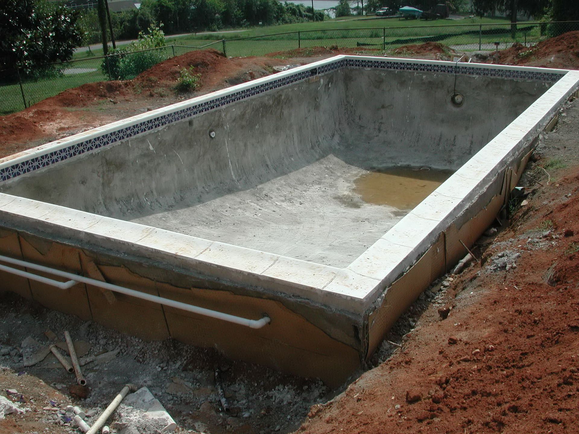 A large concrete pool is being built in the dirt