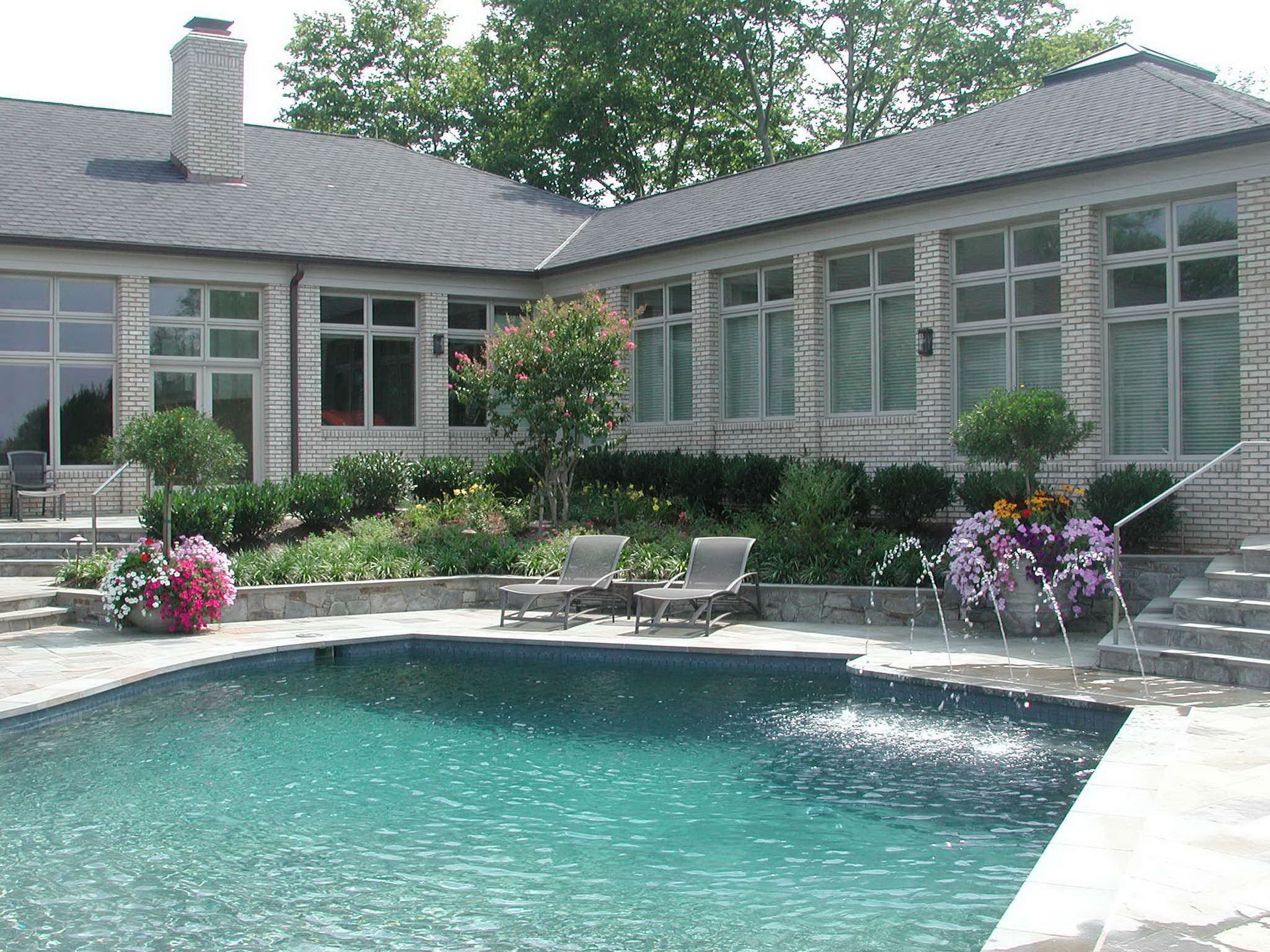 A large house with a large swimming pool in front of it.