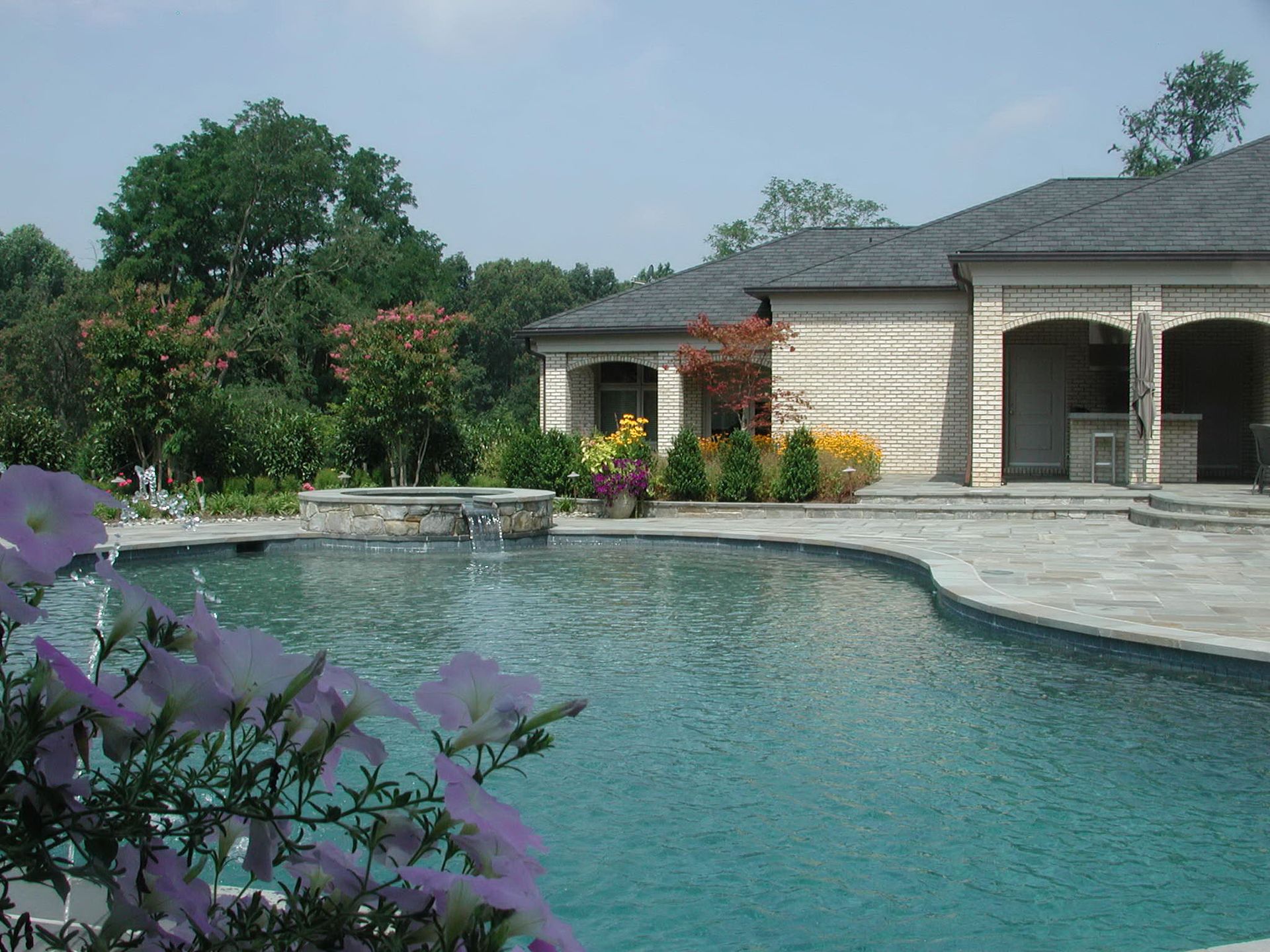 A house with a large swimming pool in front of it