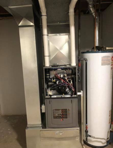 Utility room with furnace, exposed HVAC ductwork, and a white water heater.