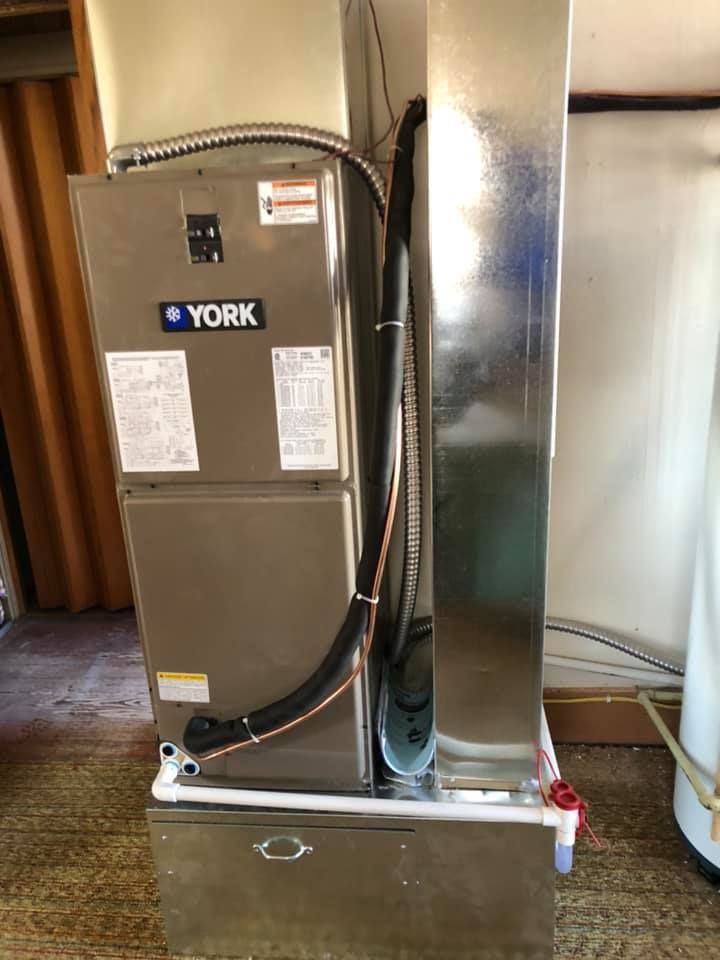 York furnace and metal ductwork in a utility room.