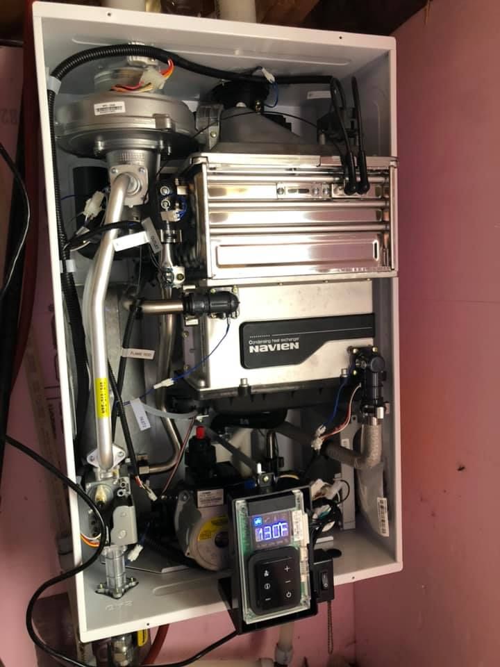 Open cabinet filled with electrical and mechanical equipment, wires, and control units.