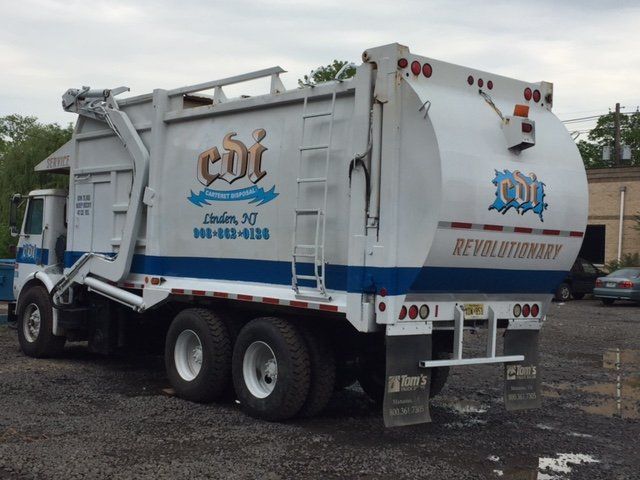 A cbt garbage truck is parked in a parking lot