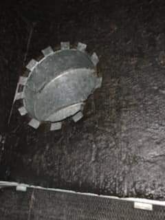 Close-up of a gray, gear-like metal knob on a dark surface