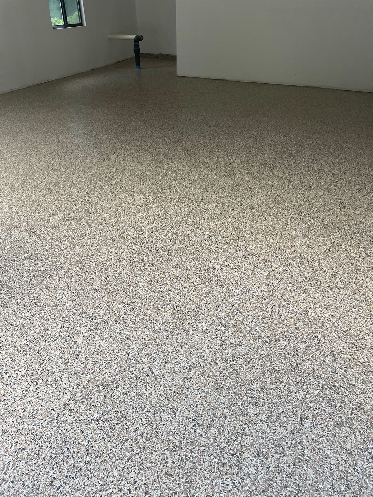 a garage with floor coatings and a window