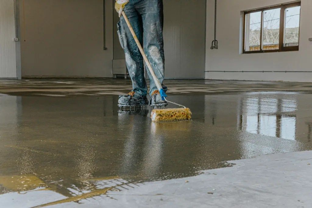 a man is applying a concrete epoxy floor coatings.