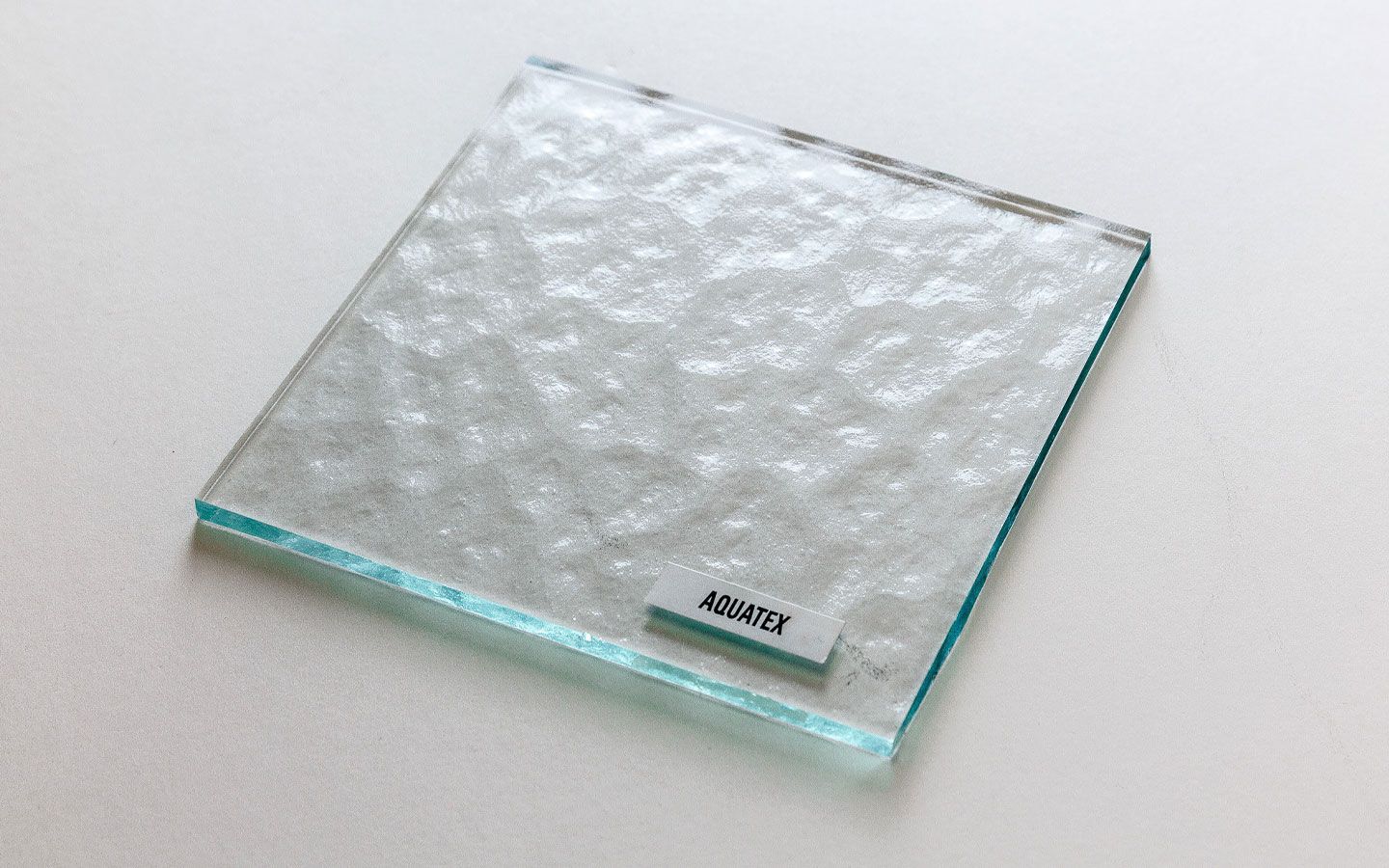 Clear glass pieces, various shapes: flat, curved, and angular, against a white background.