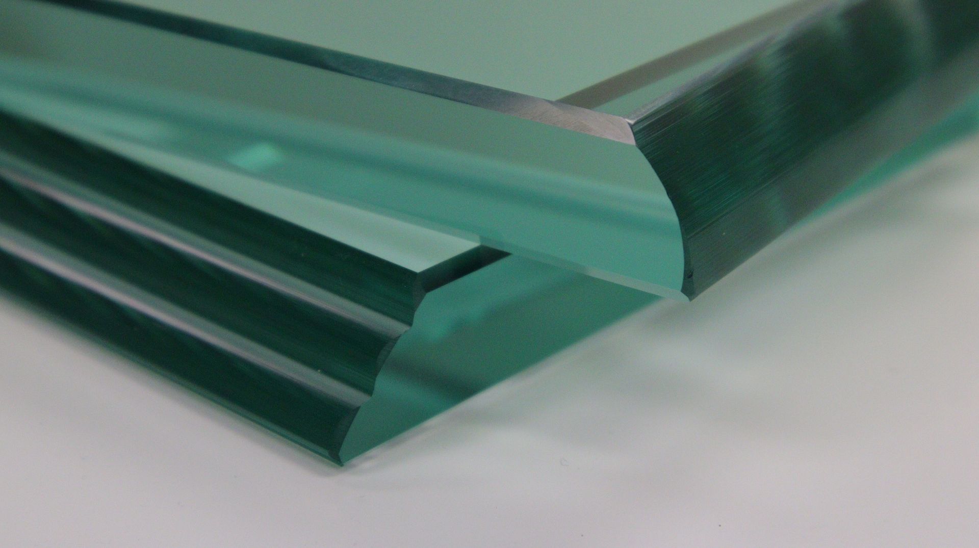 Stack of clear, beveled glass sheets with a slight green tint.