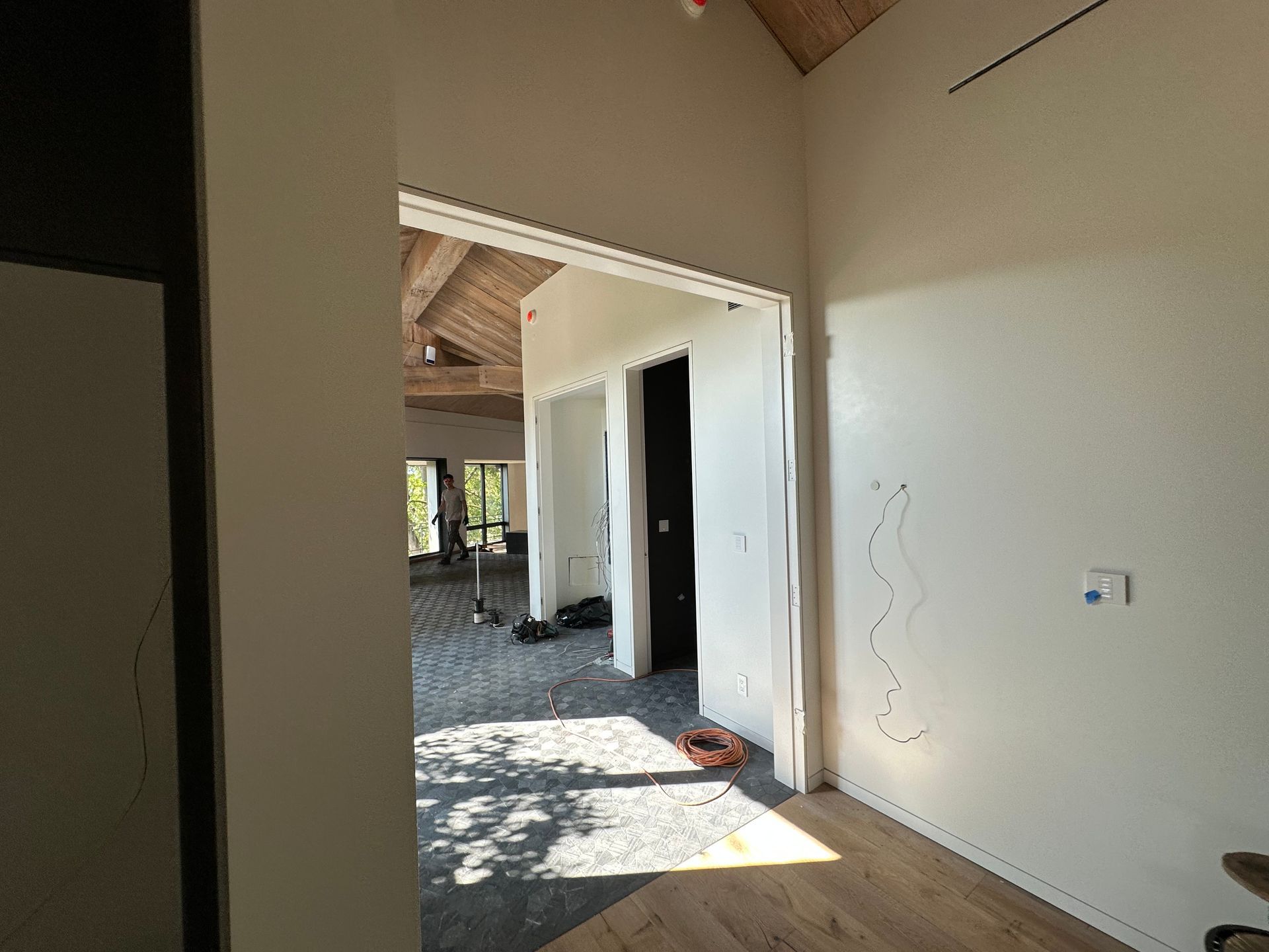 Interior hallway with unfinished walls, open doorways, and sunlight on a gravel floor