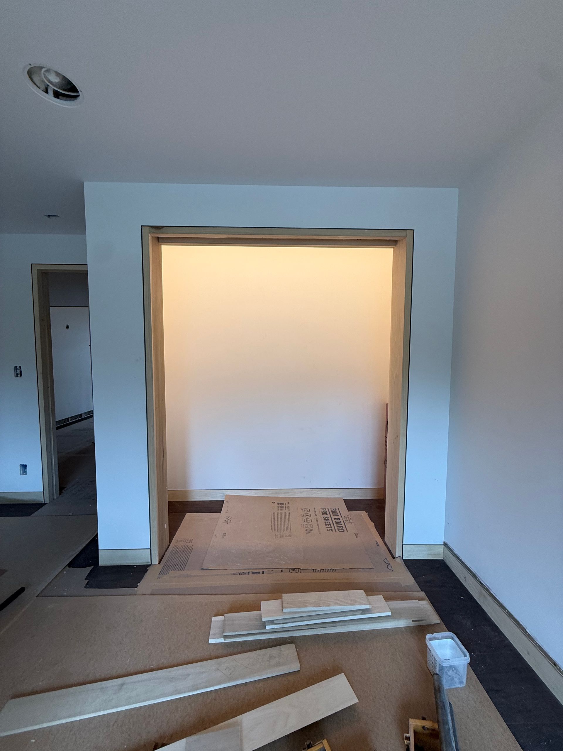 Empty room with blue walls, a doorway, and construction materials on the floor