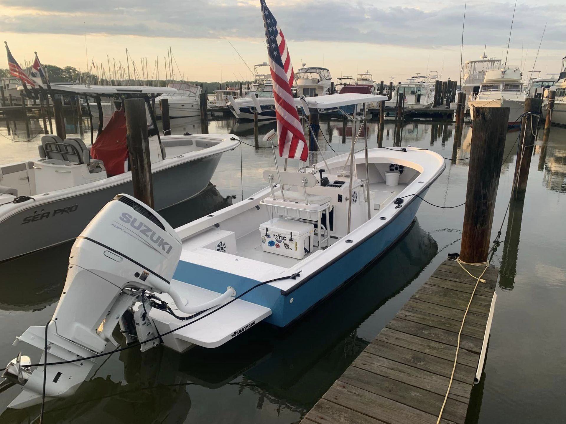 A boat with a suzuki outboard motor is docked at a marina.