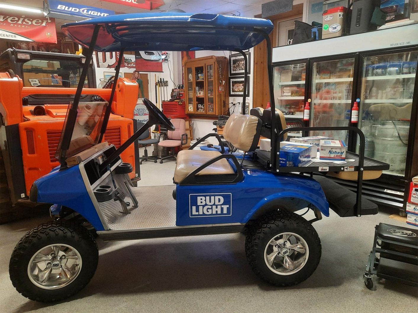 A blue golf cart with bud light written on it