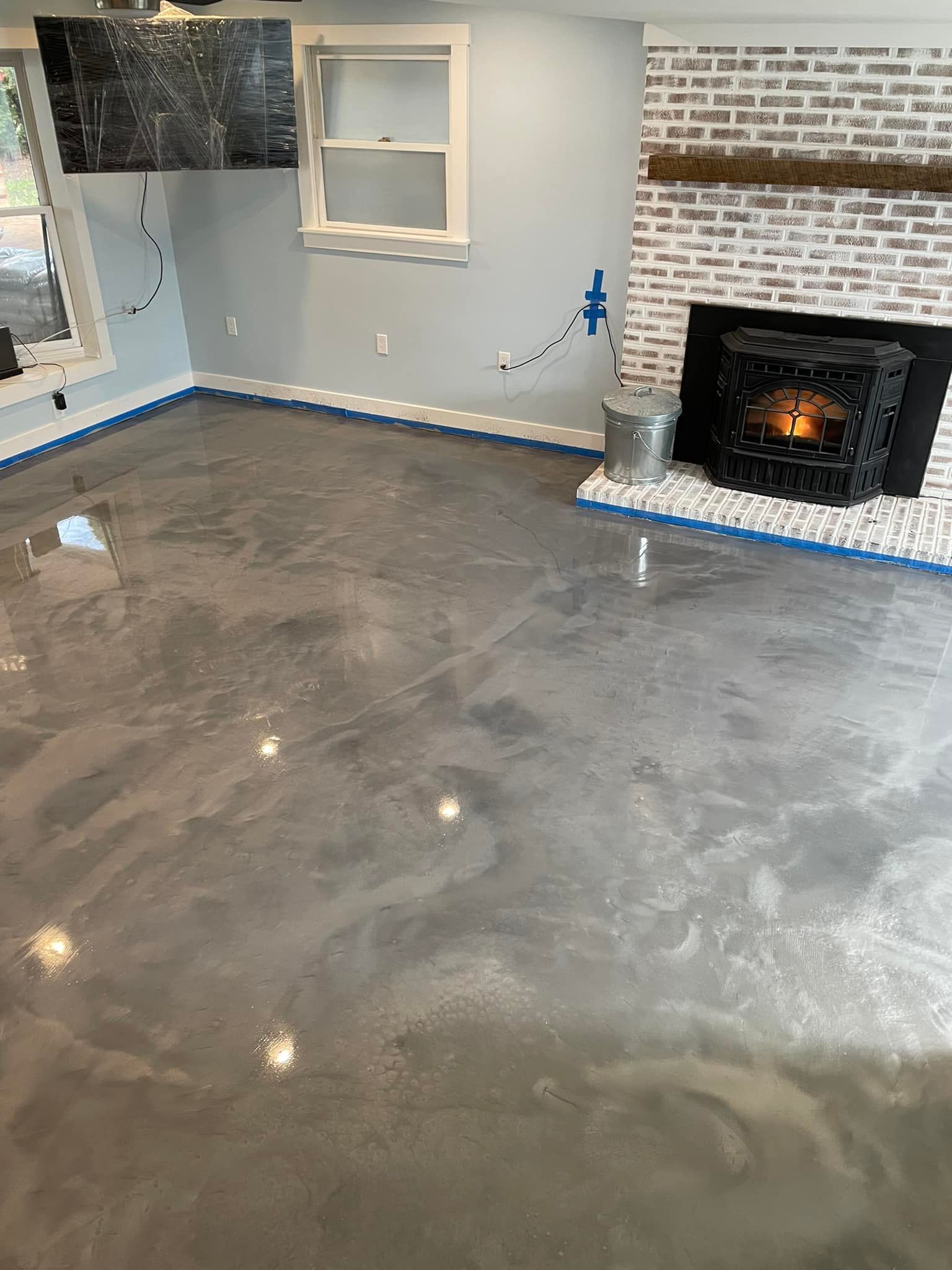 A living room with a concrete floor and a fireplace