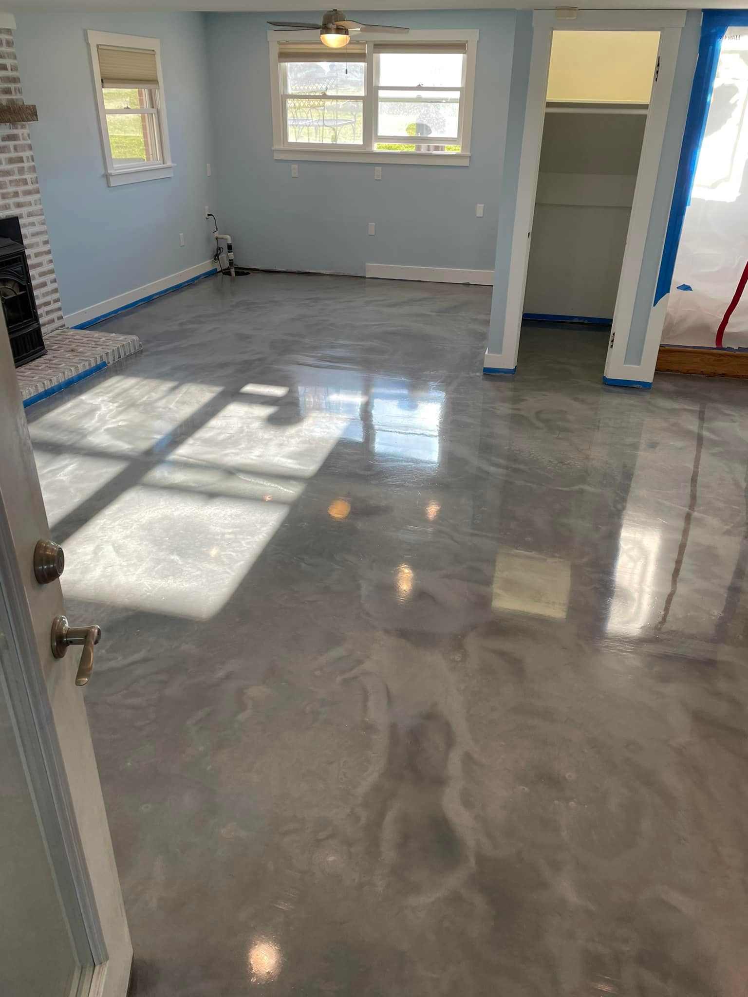 A living room with a gray metallic floor and a fireplace