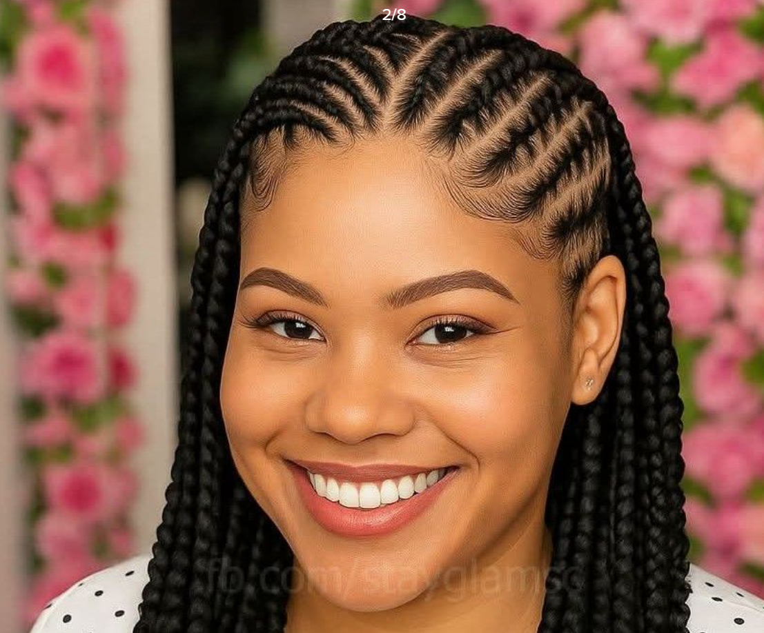 Woman with braided hairstyle smiles brightly. Pink floral background.