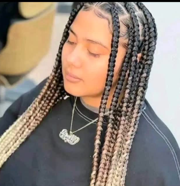 Woman with ombre box braids and a pendant necklace.