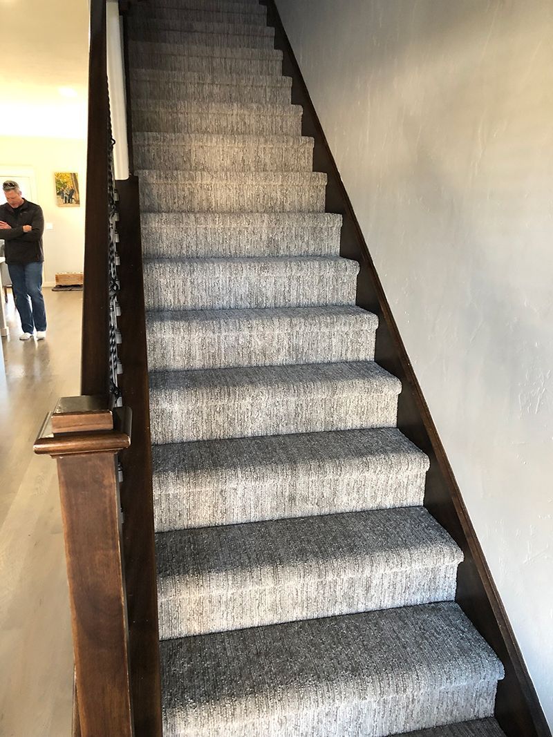 a man is standing next to a set of stairs in a house .