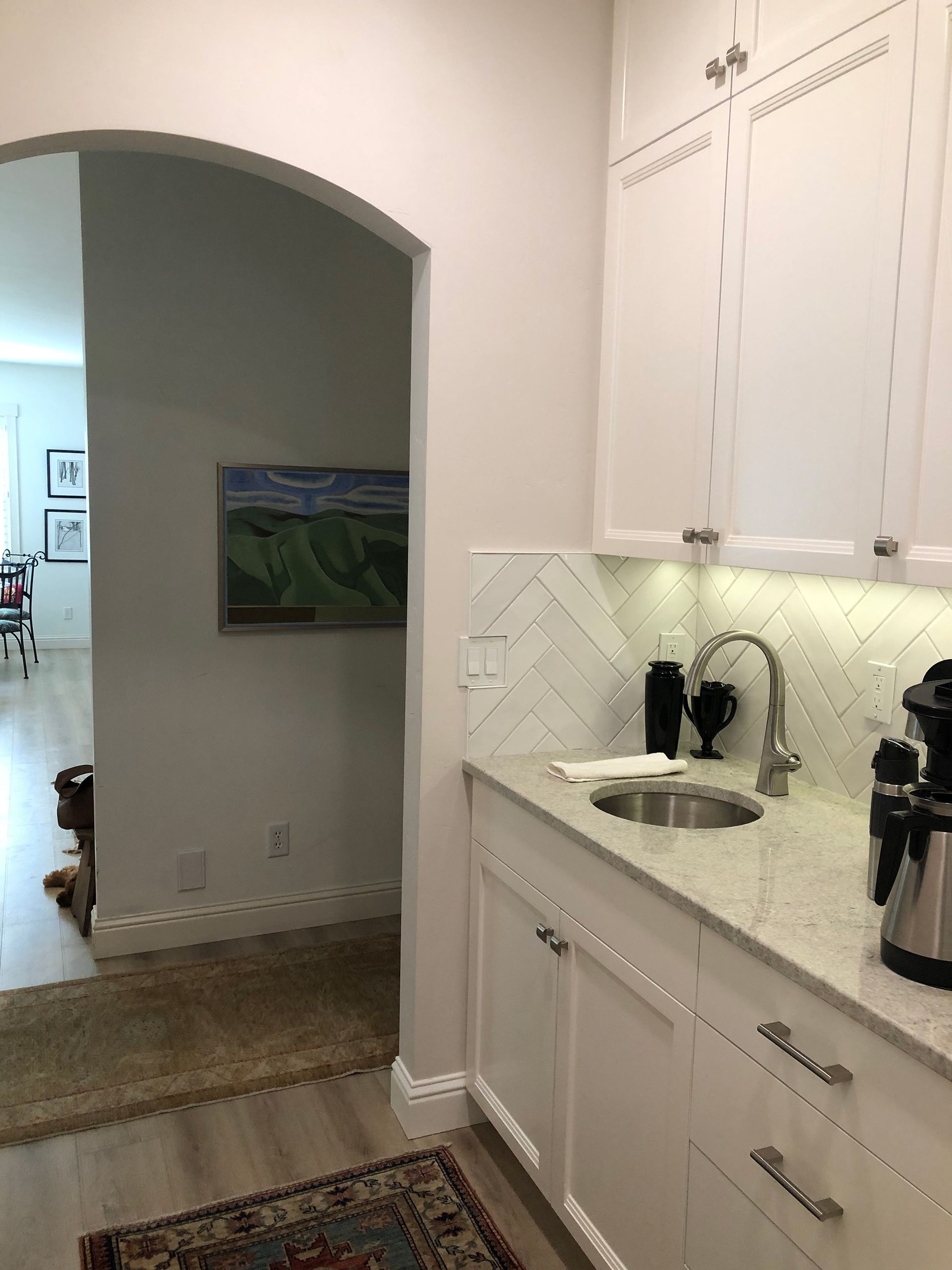 a kitchen with white cabinets and a sink .