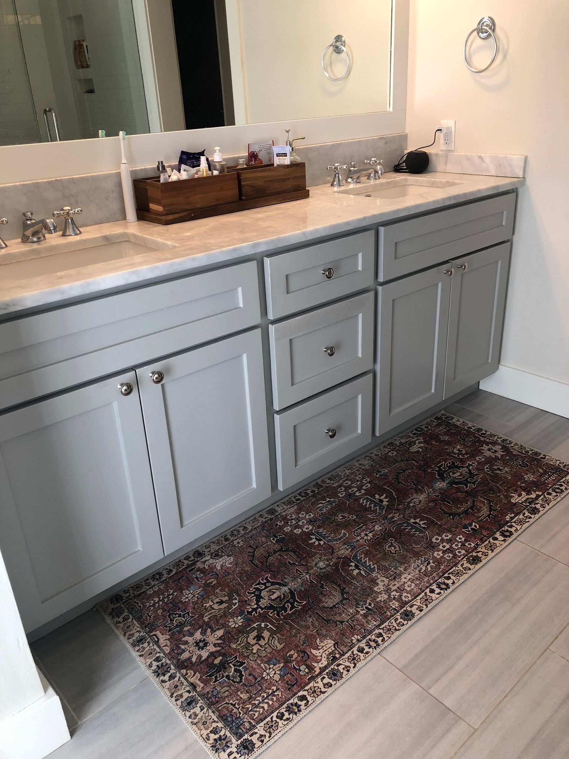 a bathroom with two sinks and a rug on the floor .