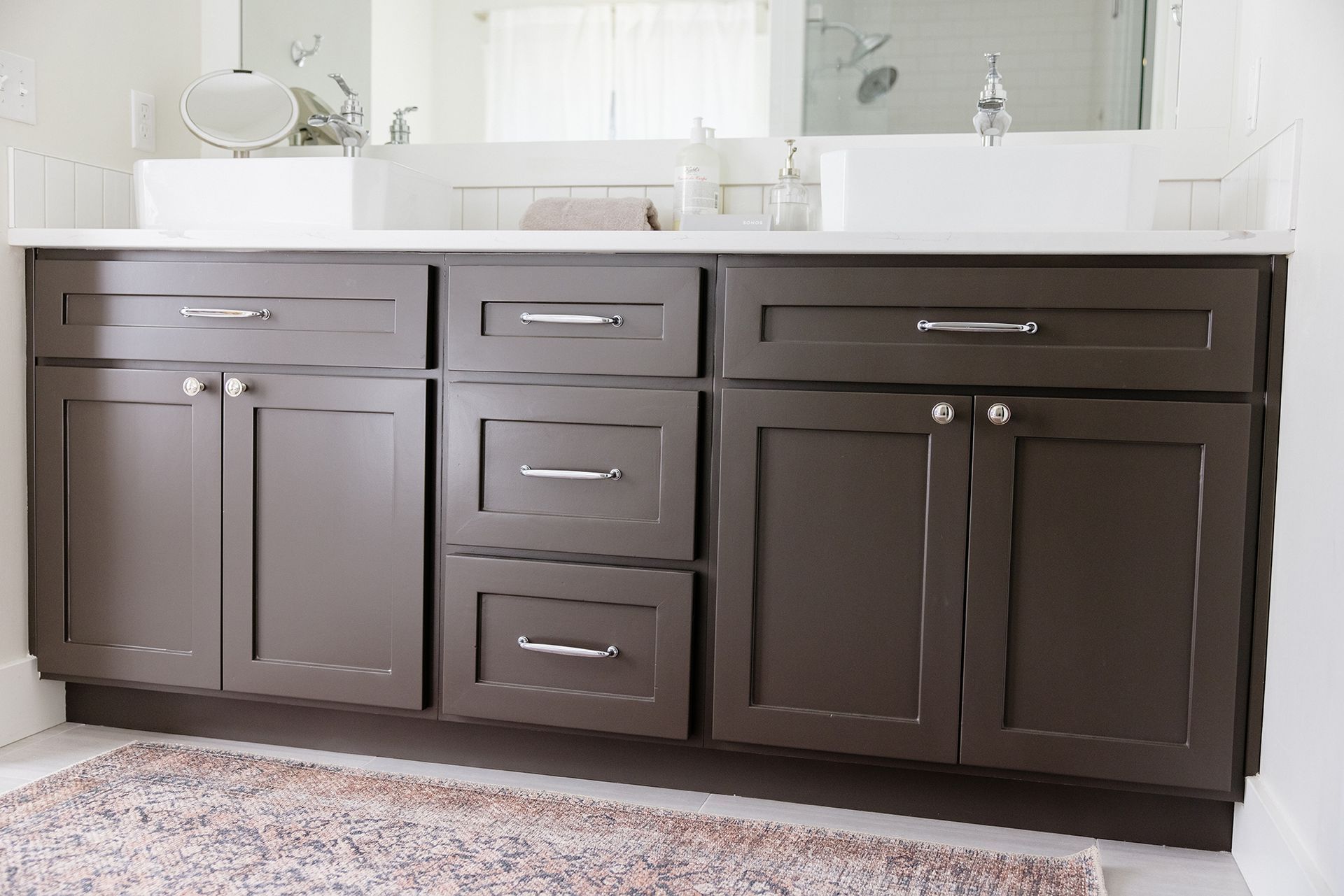 a bathroom vanity with brown cabinets and drawers and a sink .