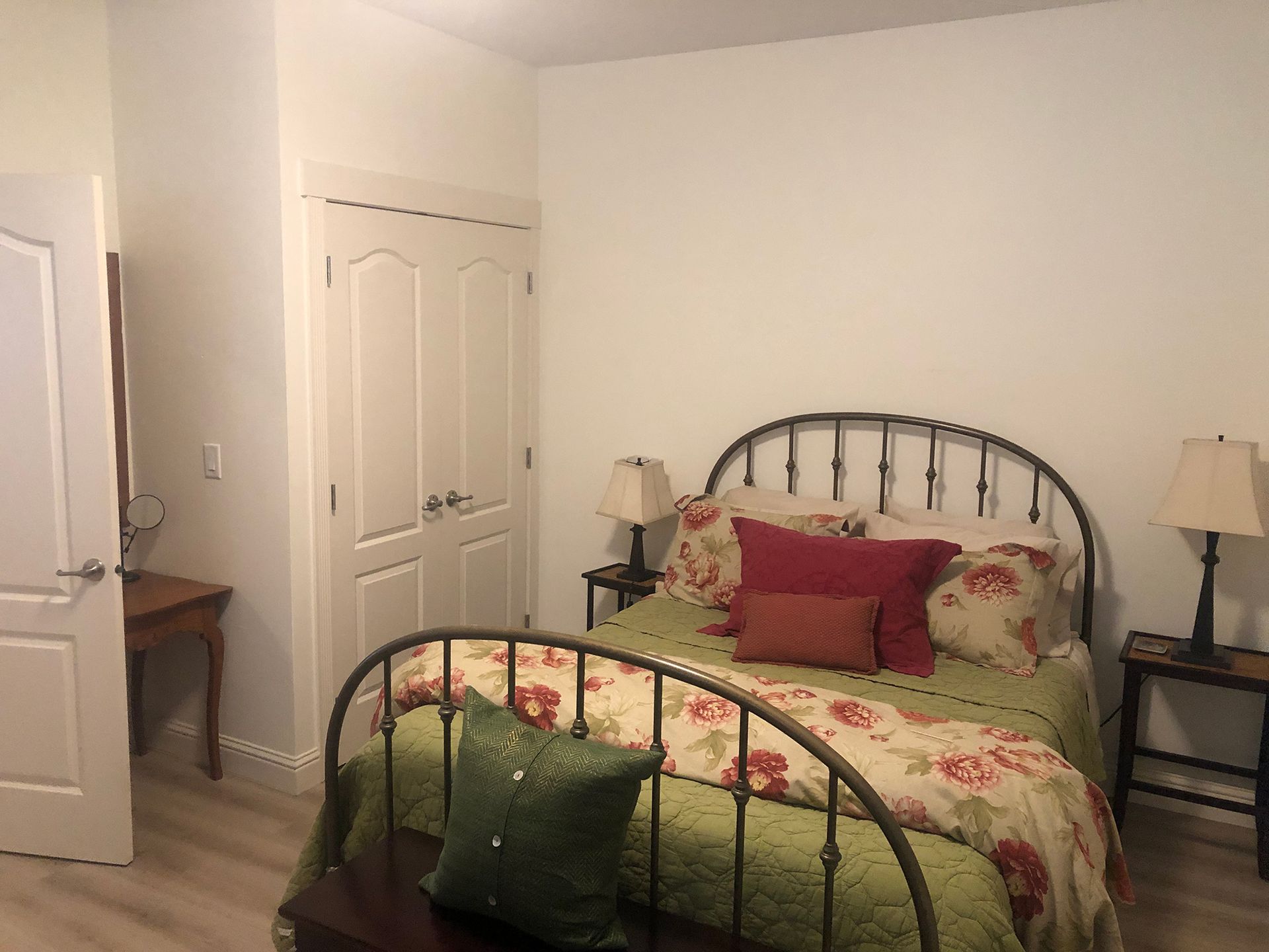 a bedroom with a bed , lamps , nightstands and a closet .