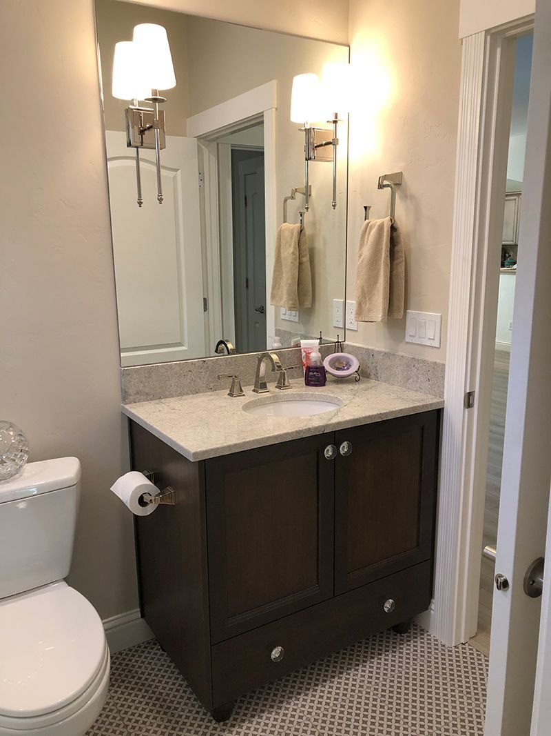 a bathroom with a toilet , sink and mirror .