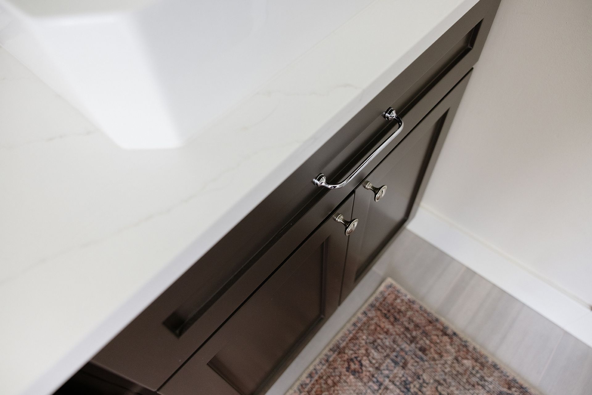 a bathroom vanity with black cabinets and a white counter top