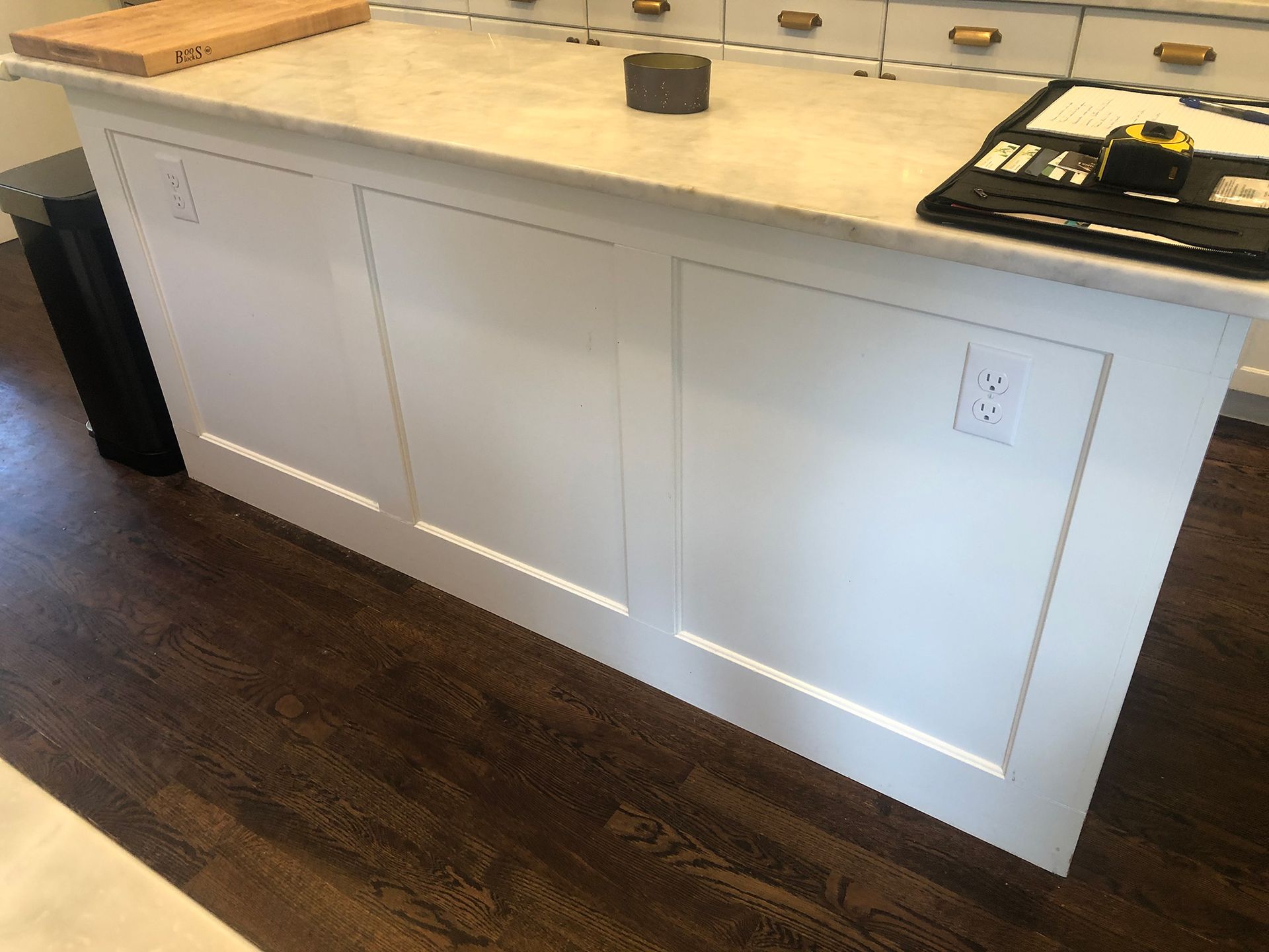 a kitchen island with a cutting board on top of it .