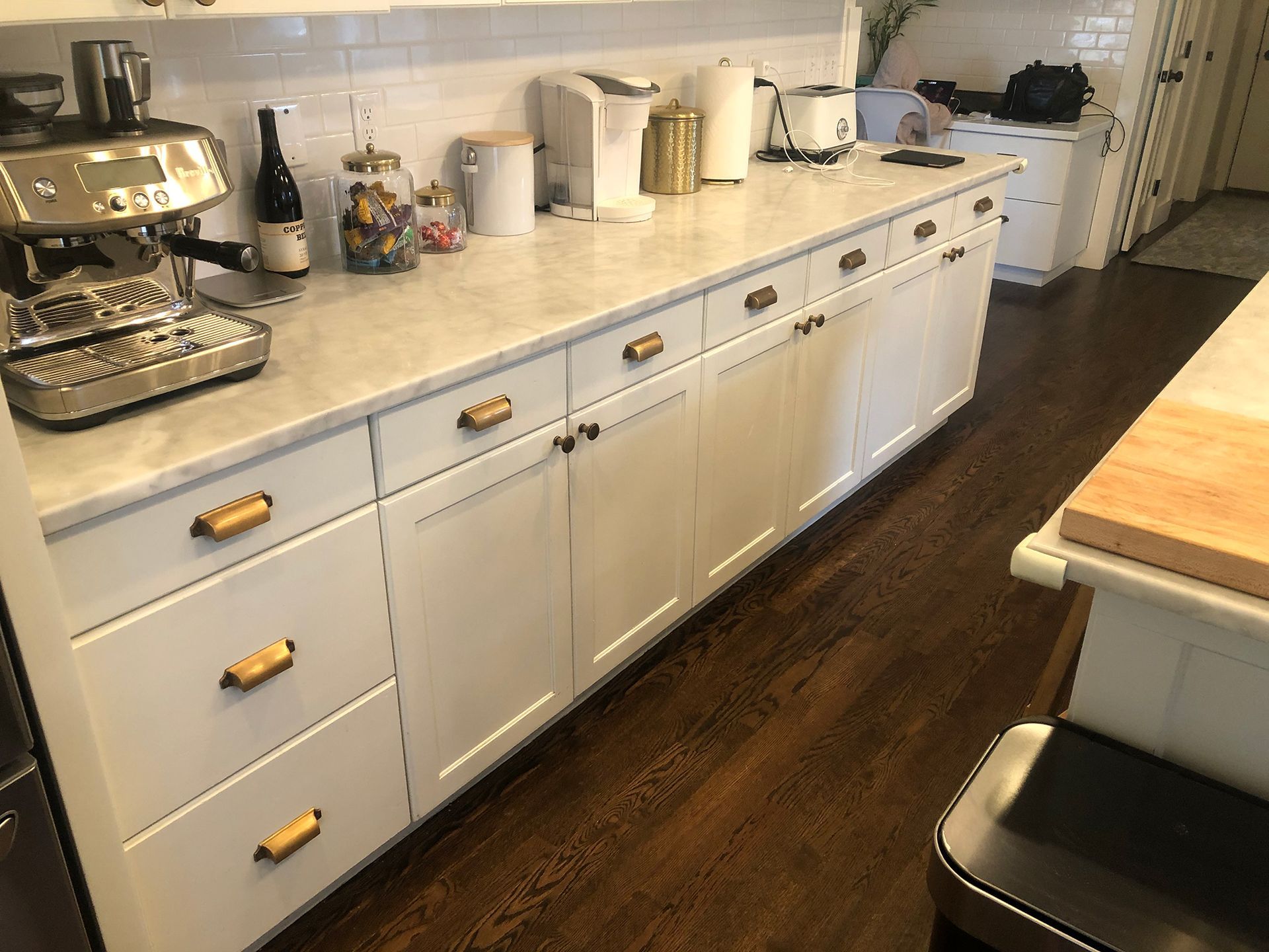 a kitchen with white cabinets and a coffee maker on the counter .