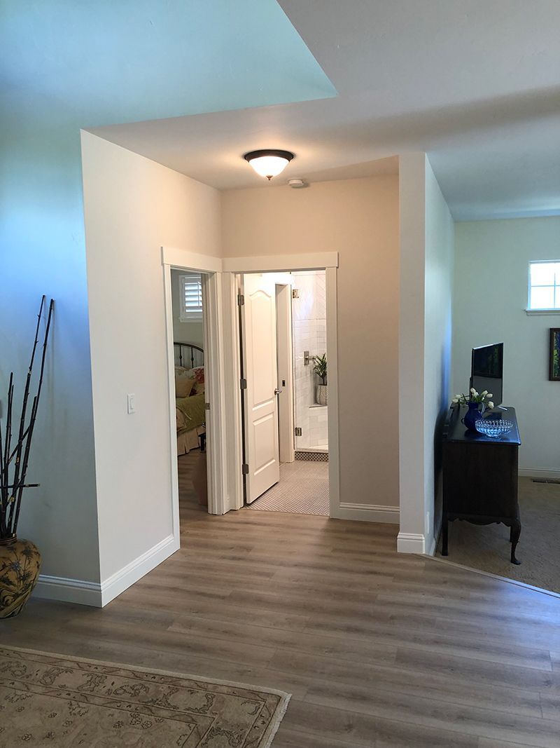 a hallway leading to a bathroom and a bedroom in a house .
