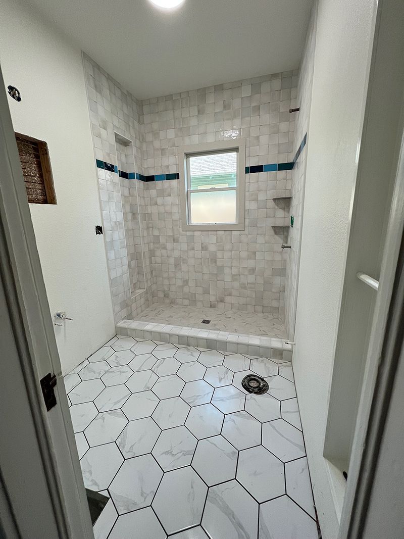a bathroom with a walk in shower and a window .
