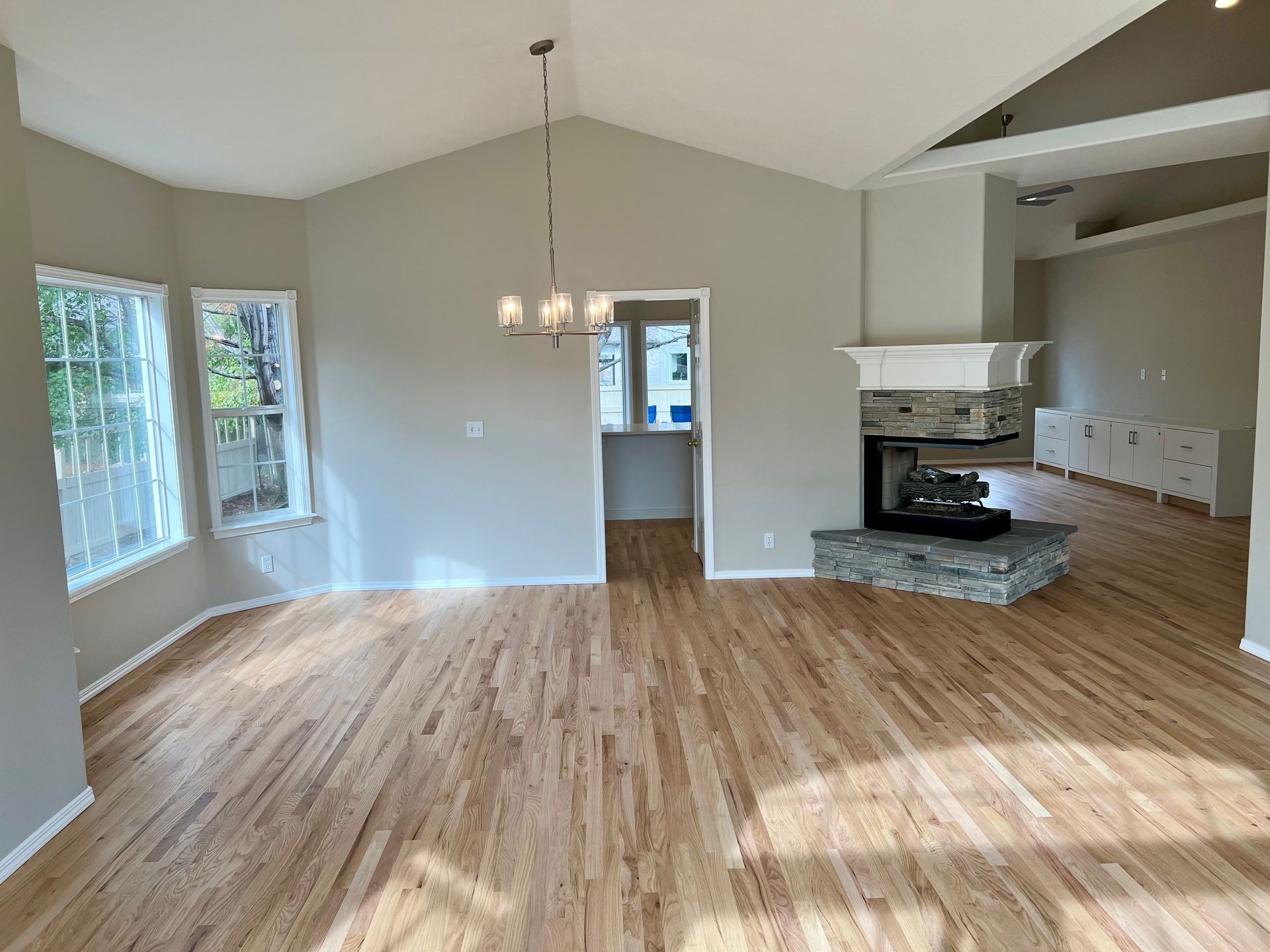an empty living room with hardwood floors and a fireplace .