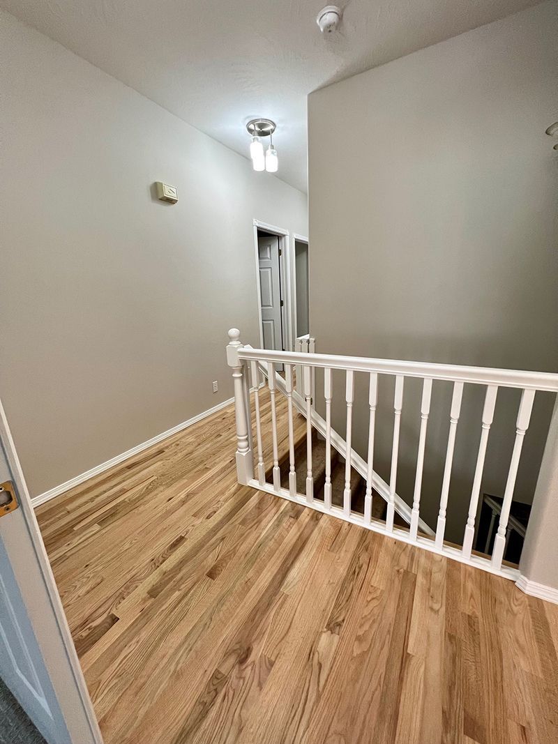 a hallway with hardwood floors and stairs in a house .