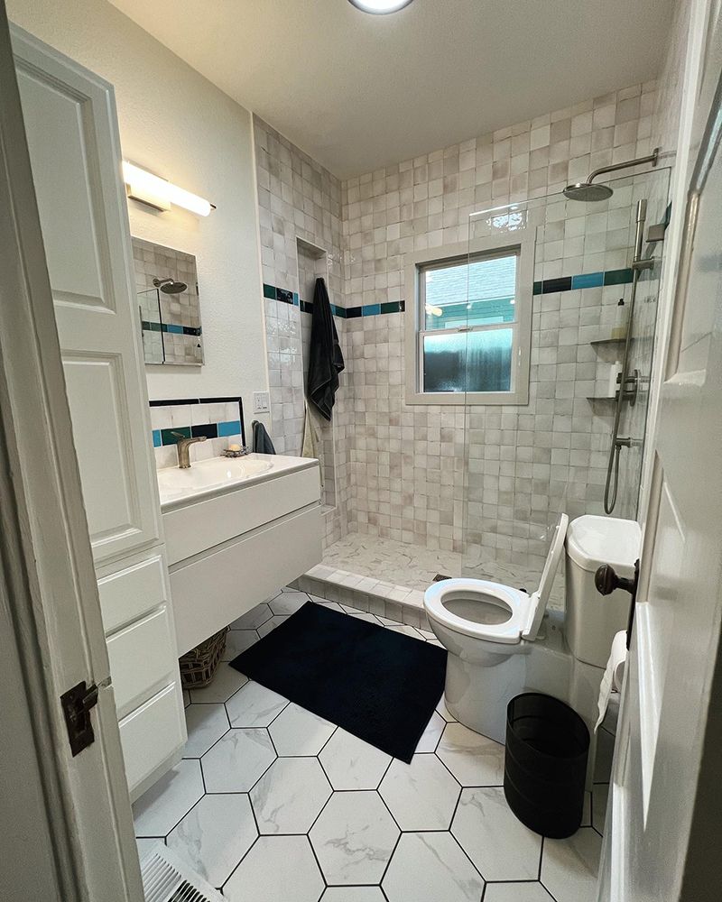 a bathroom with a toilet , sink and shower .