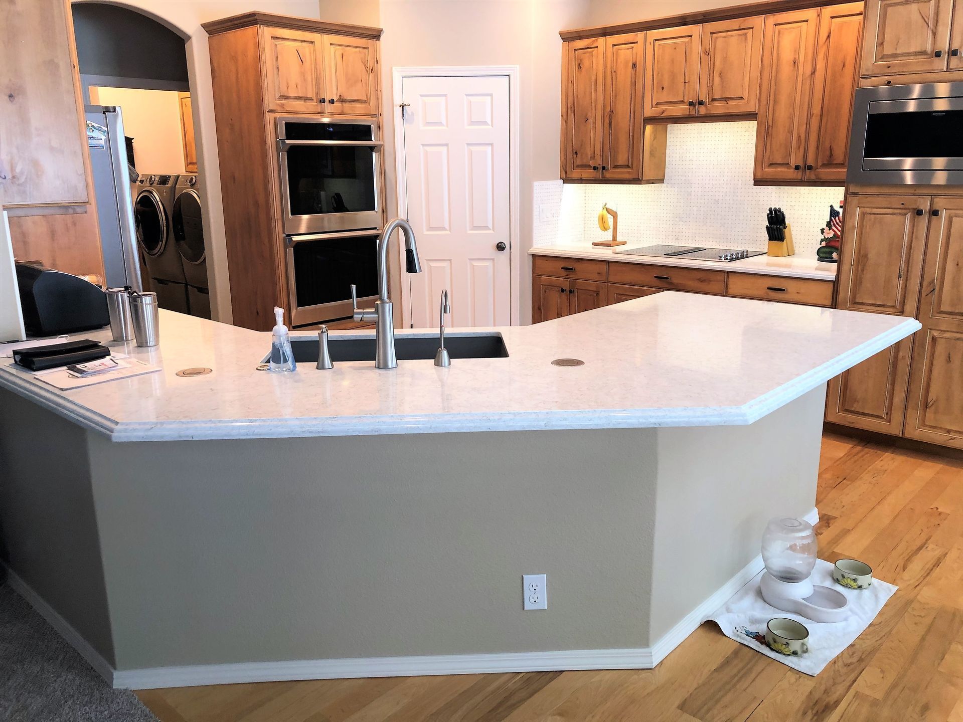 a bedroom with a king size bed , a bench , a lamp , and two windows .