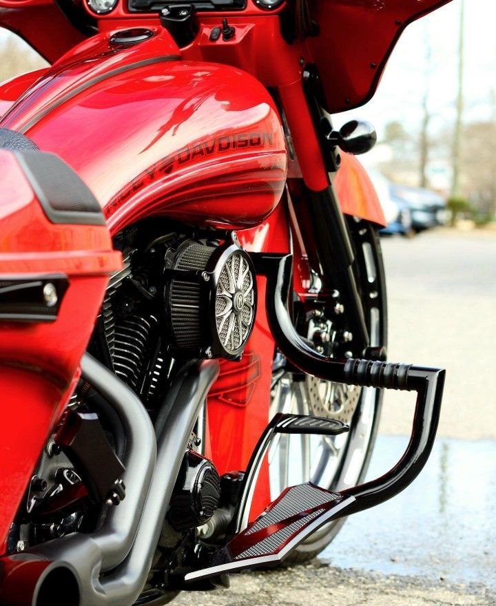 Red Harley-Davidson motorcycle with custom black accents; parked on pavement.