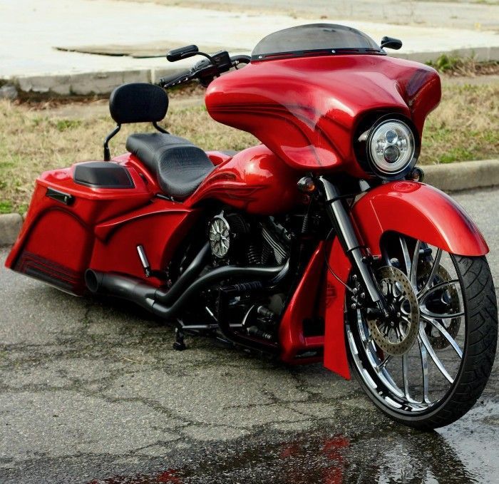 Red custom motorcycle with large fairing and chrome wheels.