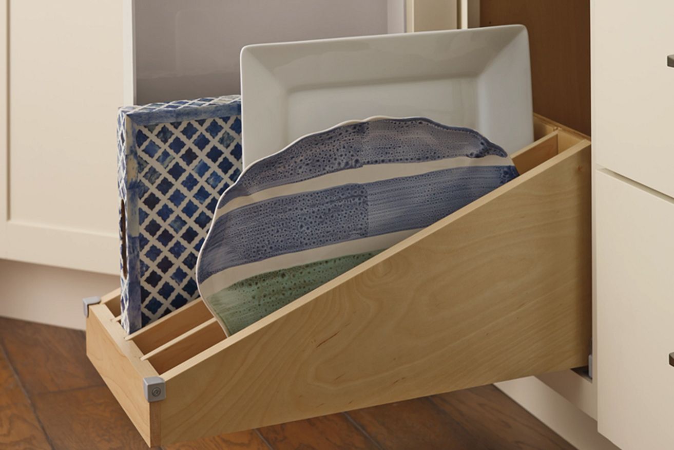 A wooden drawer with plates and towels in it