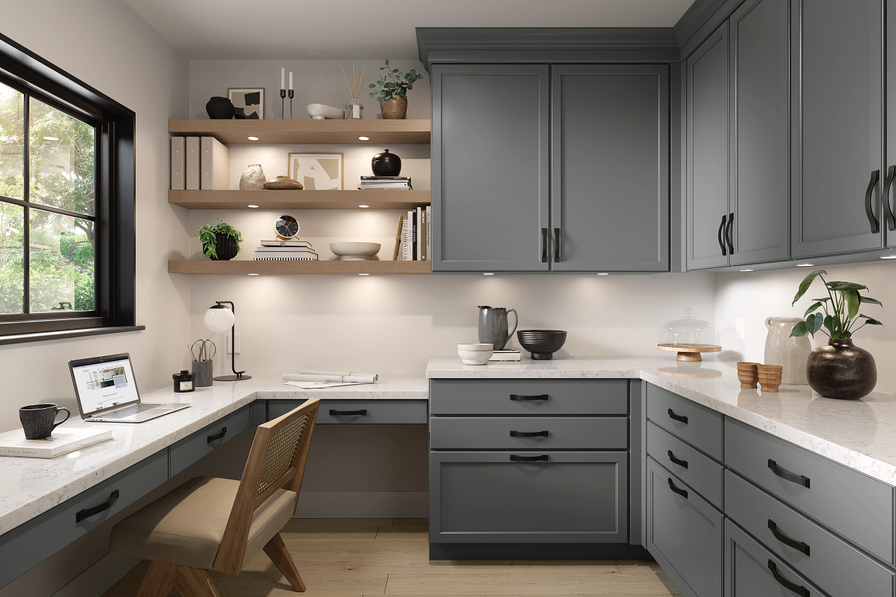 A home office with gray cabinets and a desk with a laptop on it.