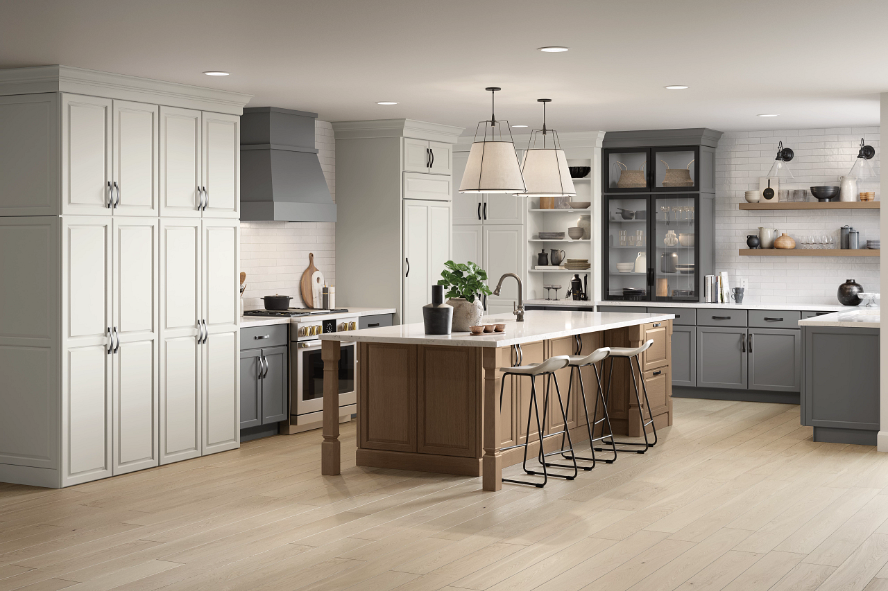 A kitchen with white cabinets , gray cabinets , and a large island.