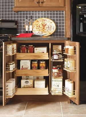 A kitchen cabinet with a pull out drawer filled with jars and boxes