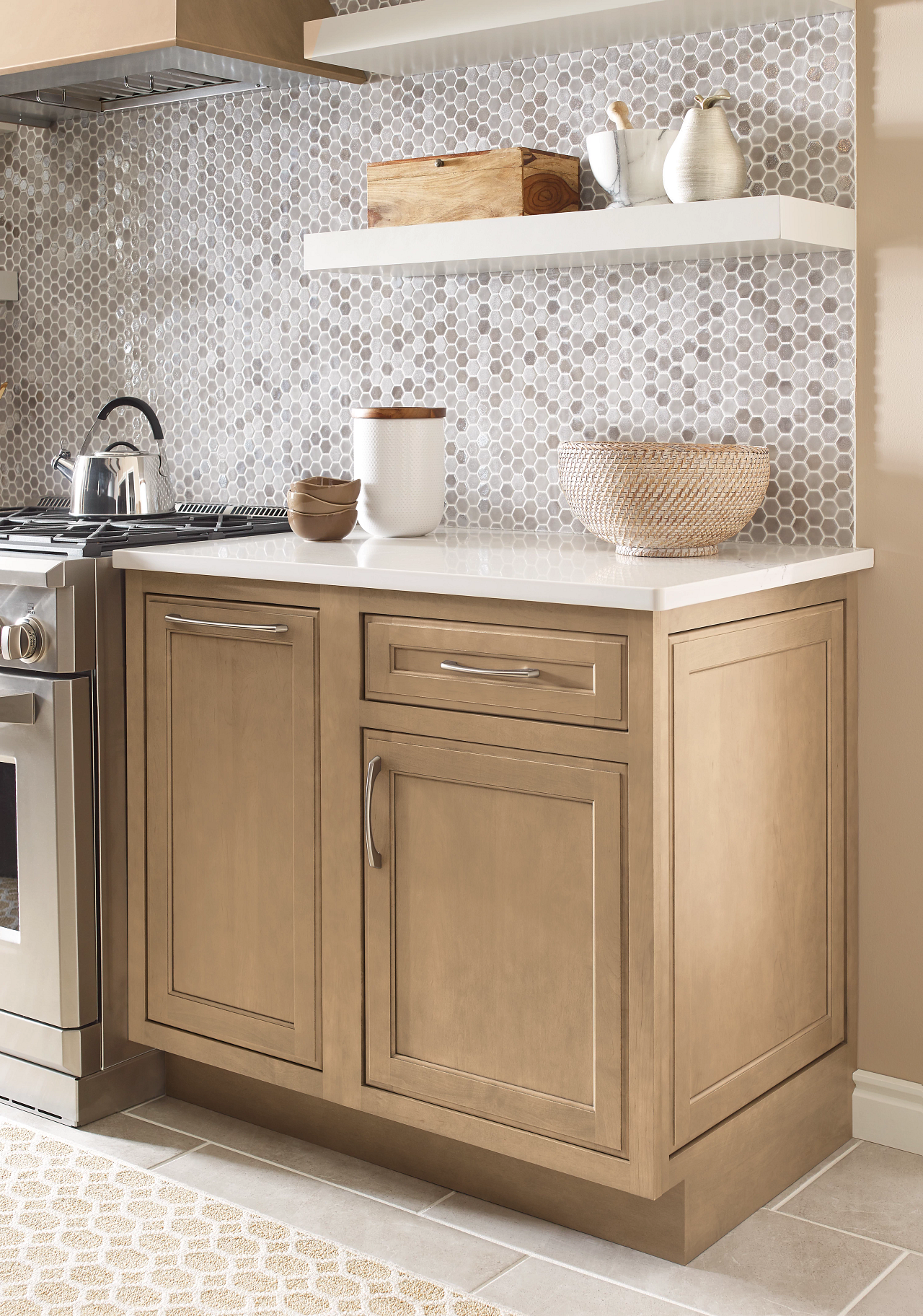 A kitchen with wooden cabinets , a stove , and a shelf.