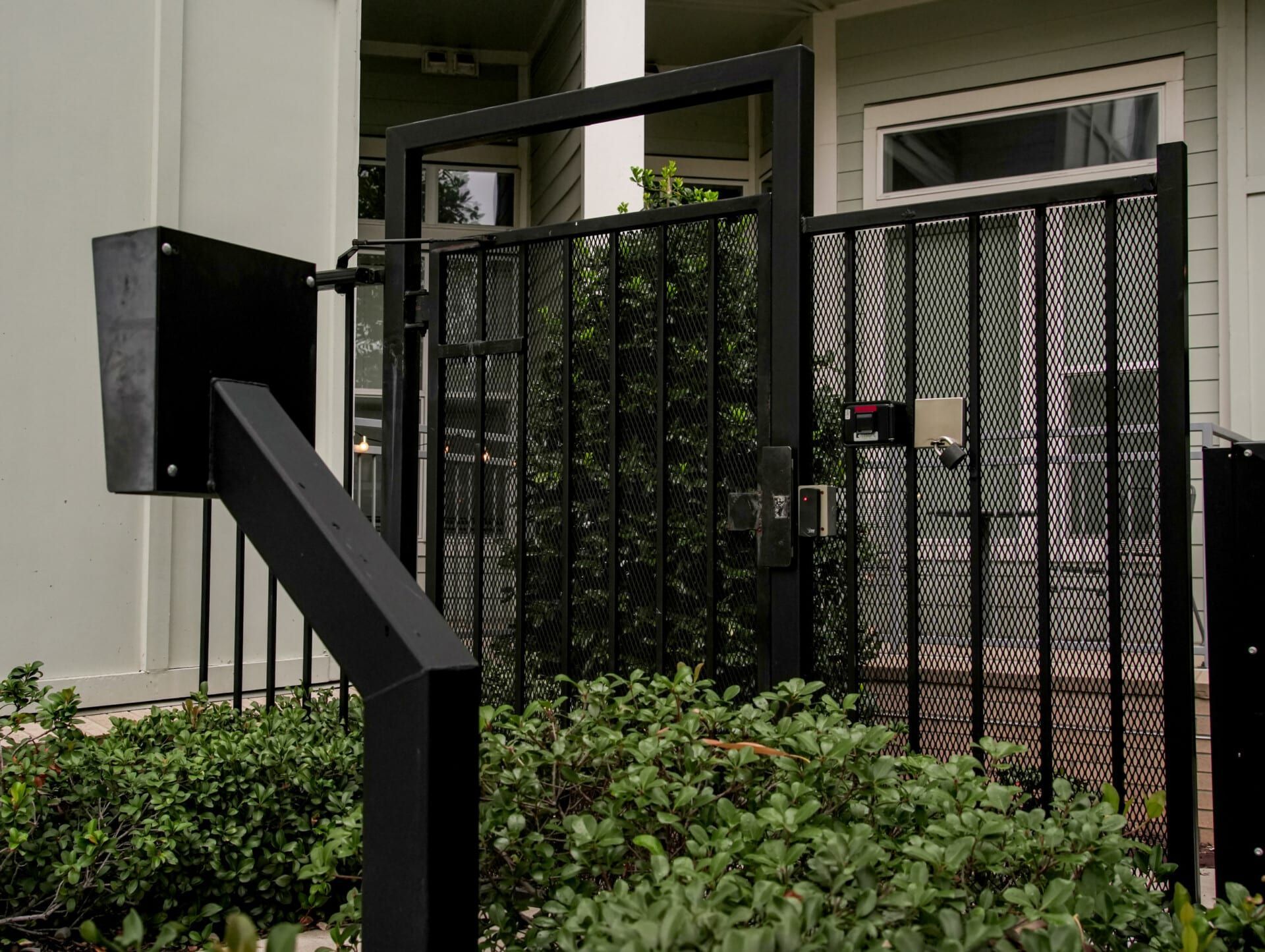 A black fence with a mailbox attached to it