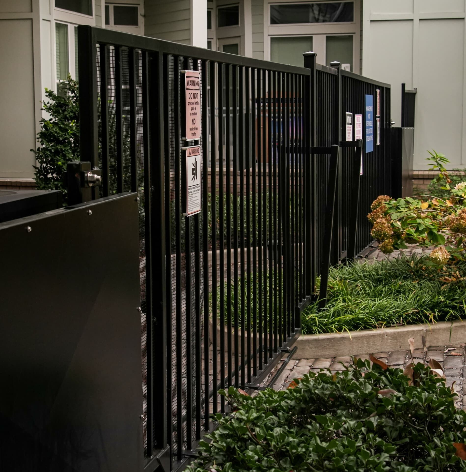 A black fence with a sign on it that says no parking