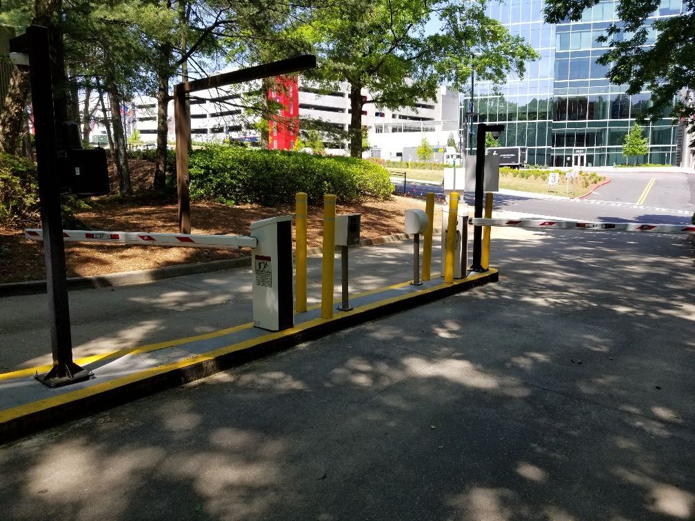 A parking lot with a barrier and a building in the background