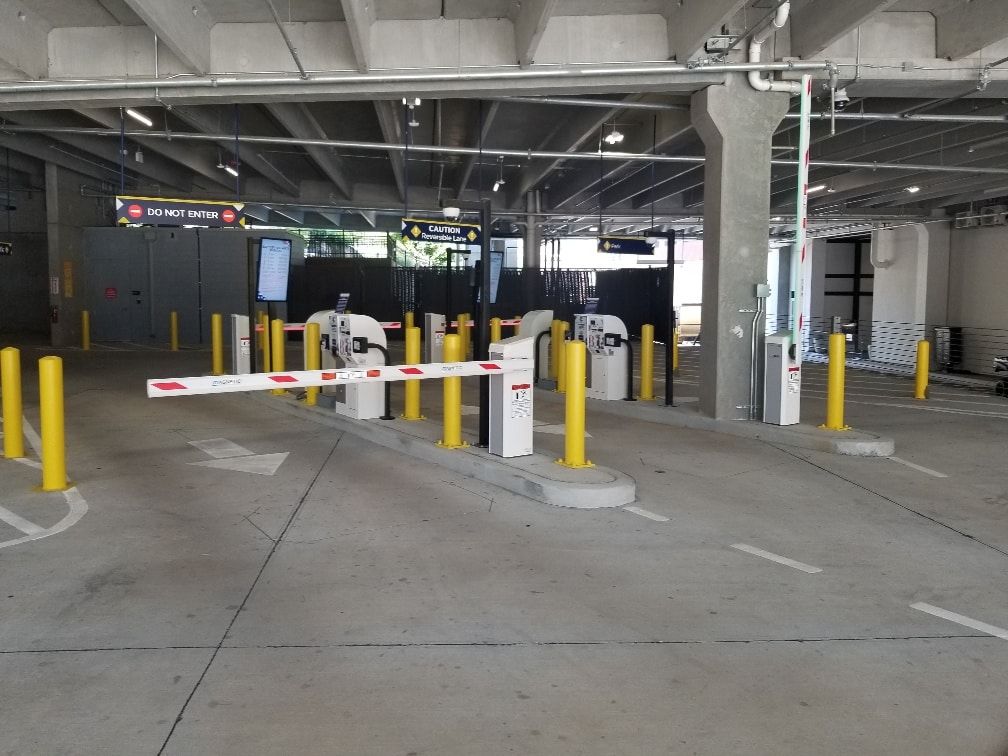 A parking garage with a lot of barriers and yellow poles