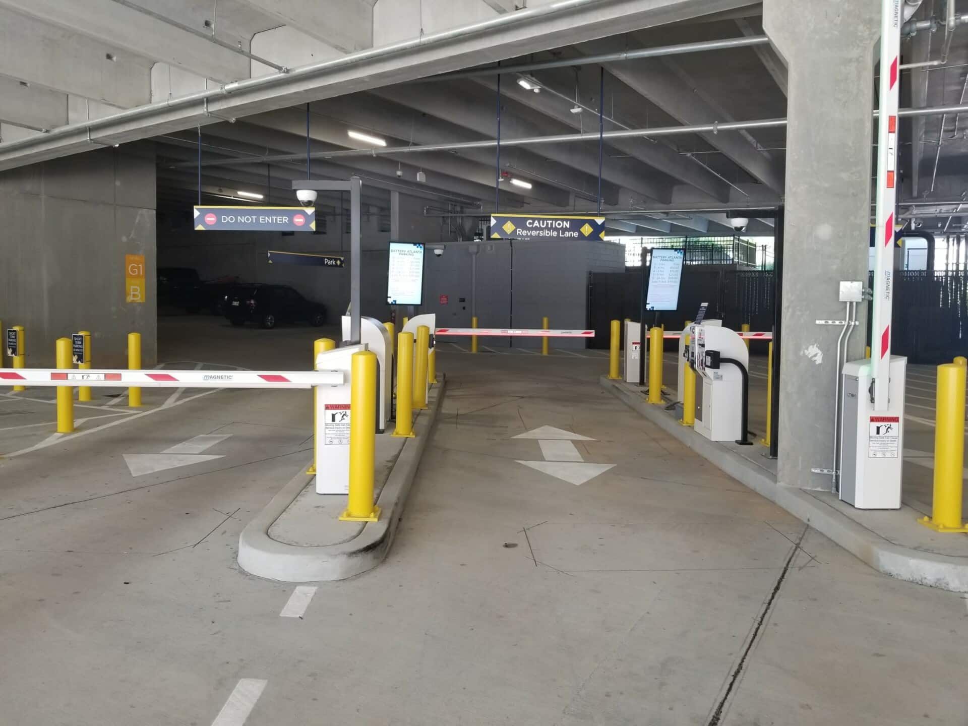 A parking garage with a lot of yellow poles and barriers