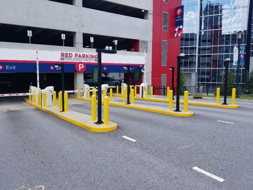 A red parking garage with a lot of yellow poles