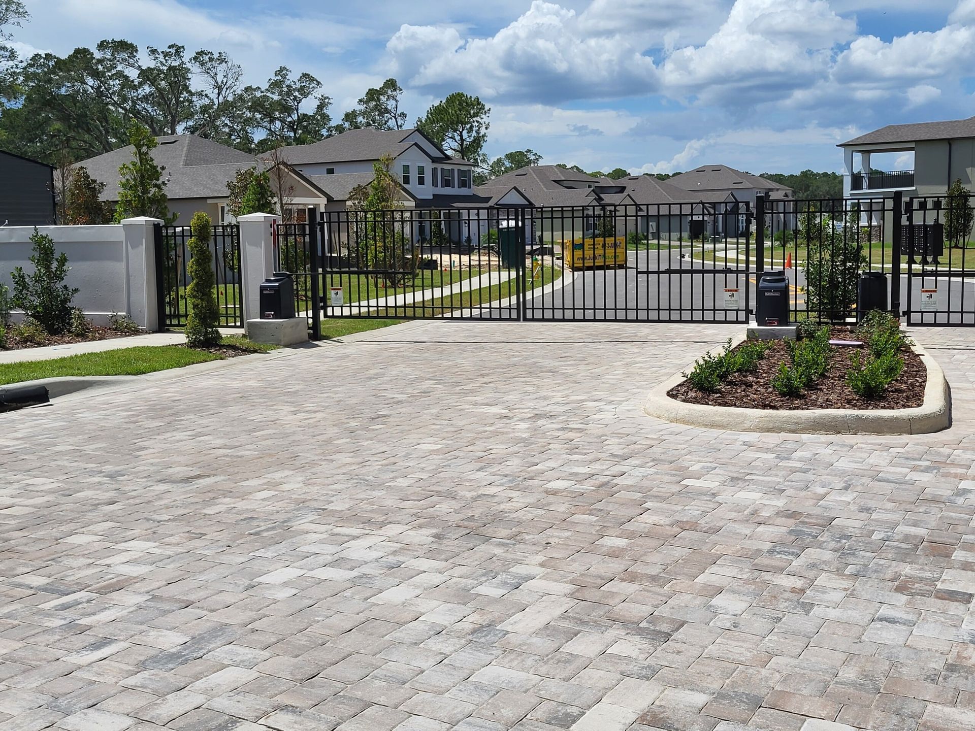 A brick driveway with a gate in the middle of it